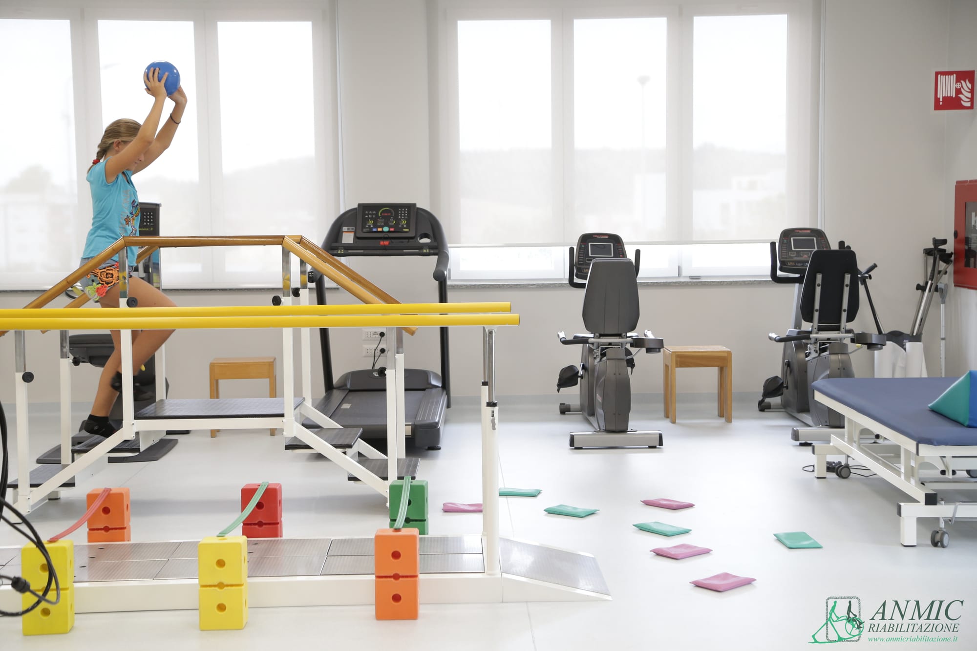 Palestra per la riabilitazione dell'età evolutiva con parallele e tappetini colorati